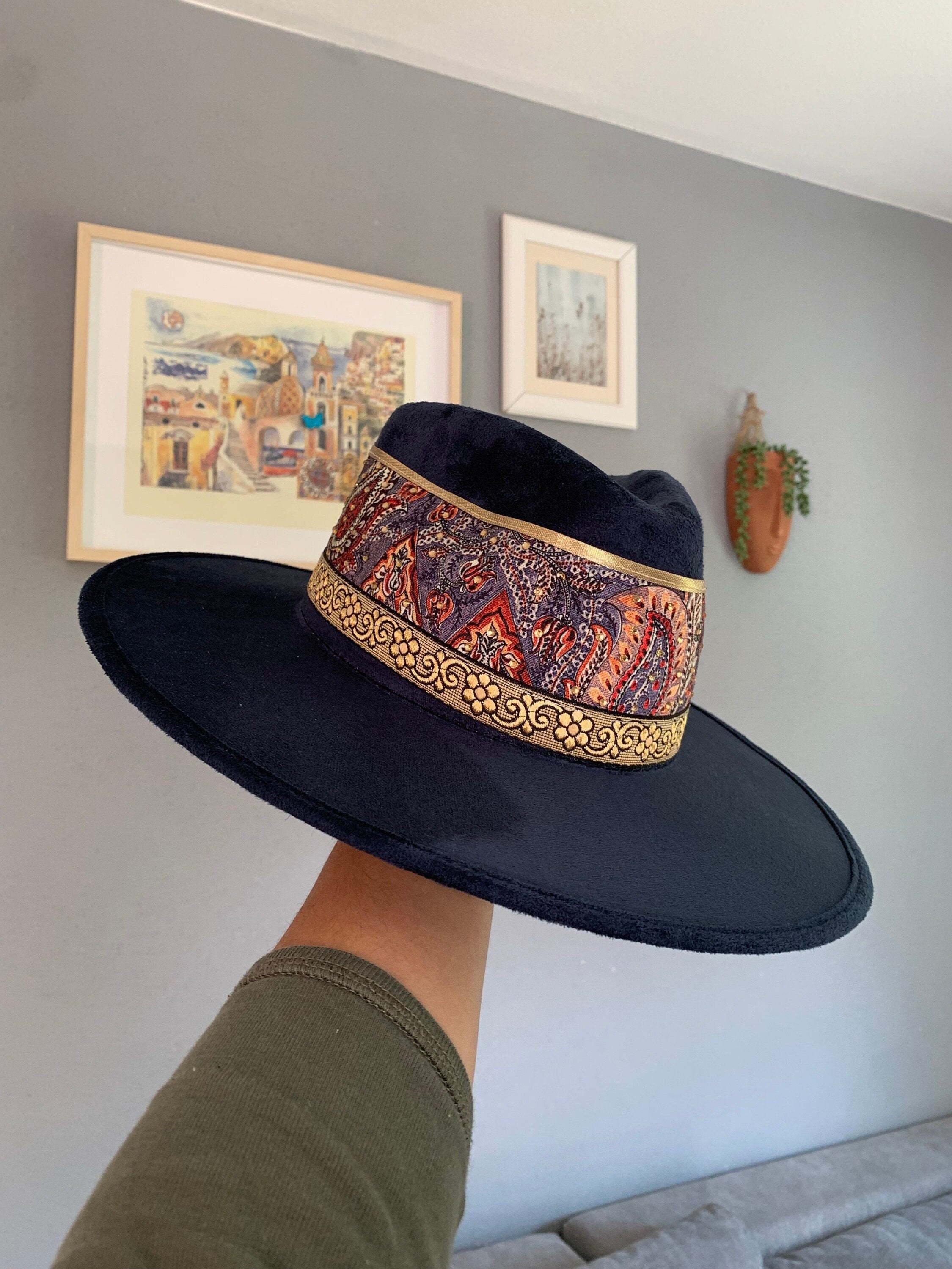 Eleganter schwarzer Hut mit breiter Krempe und buntem, gemustertem Band. Perfekt für stilvolle Mode, Accessoires und trendige Outfits.