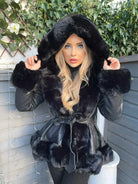 Frau in schwarzem Kunstpelzmantel mit Kapuze, stilvoll und warm, ideal für Wintermode. Perfekt für elegante, trendige Winteroutfits.