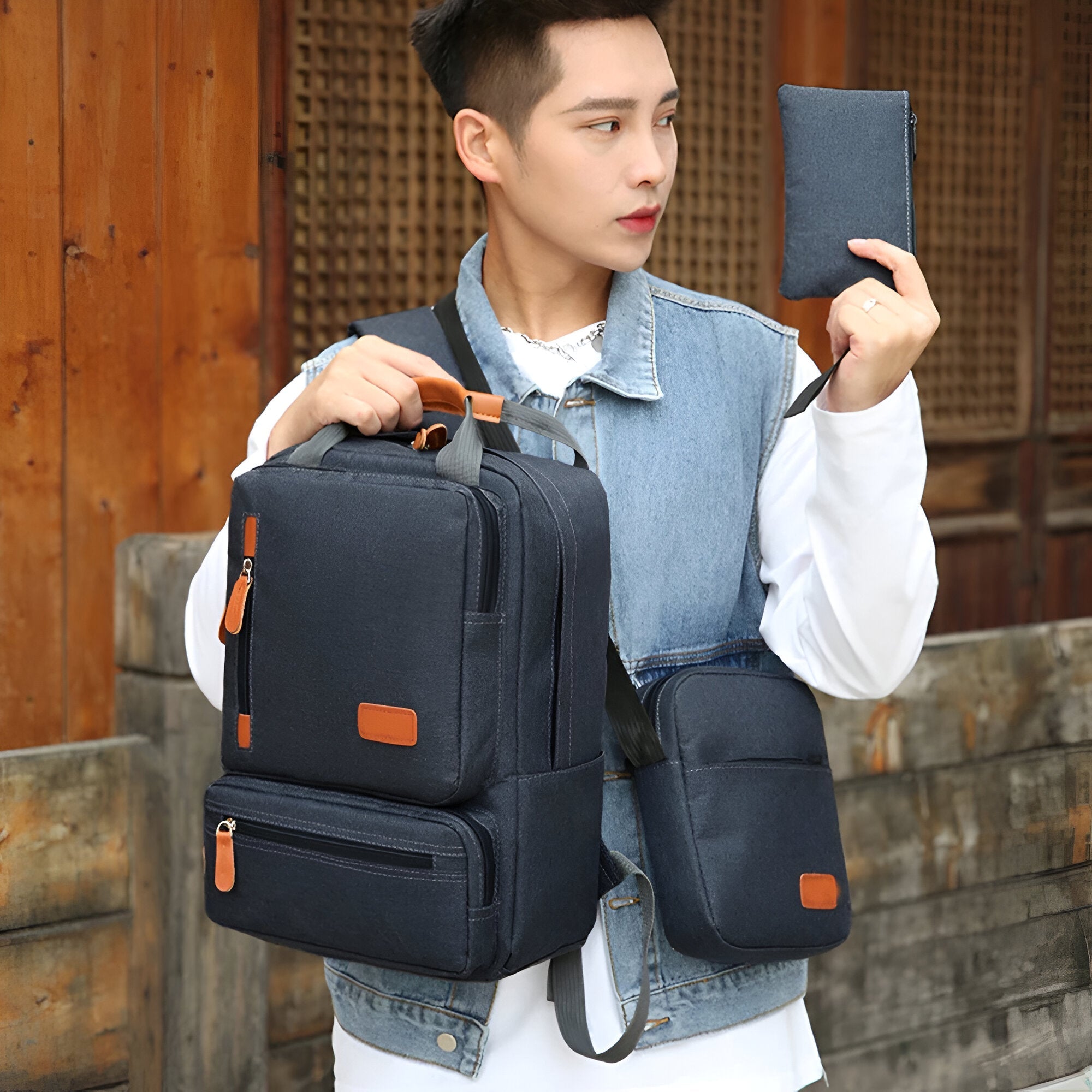Mann mit schwarzem Rucksack und passender Tasche, Denim-Weste, urbaner Stil.