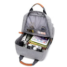 Grauer Rucksack mit Kamera, Tablet und Zubehör, ideal für Reisen und Fotografie.