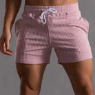 Gestreifte Herren-Badeshorts in Rosa mit weißem Kordelzug, ideal für Strand und Pool. Modische Badehose, bequem und stilvoll.