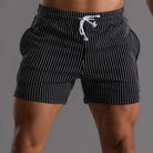 Schwarze Herren-Badeshorts mit weißen Streifen, elastischem Bund und Kordelzug. Ideal für Strandmode und Sommertrends.