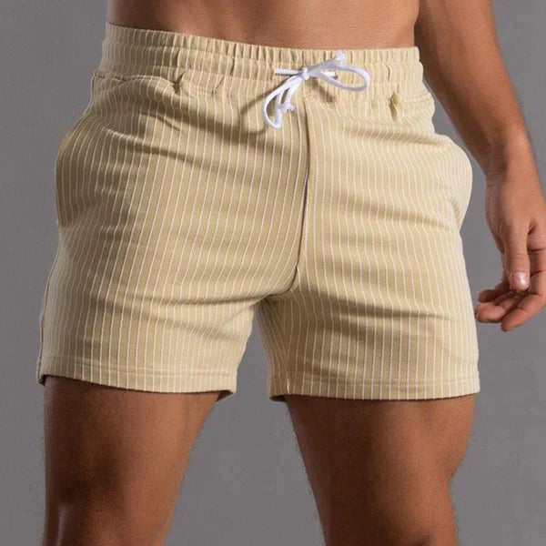 Herren-Badeshorts in Beige mit weißen Streifen, elastischem Bund und Kordelzug. Ideal für Strandmode und Sommertrends. Hochwertige Badebekleidung.