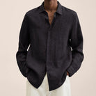 Schwarzes Leinenhemd für Herren, lässig und stilvoll, ideal für Sommermode. Perfekt kombinierbar mit weißen Hosen für einen eleganten Look.
