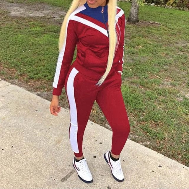 Klassisches rotes Trainingsanzug-Set für Damen, sportlich und modisch, ideal für Fitness und Freizeit. Perfekt kombiniert mit weißen Sneakers.