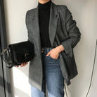 Damenmode: Eleganter grauer Karoblazer kombiniert mit schwarzem Rollkragenpullover und blauer Jeans. Perfekt für stilvolle Herbst-Looks.