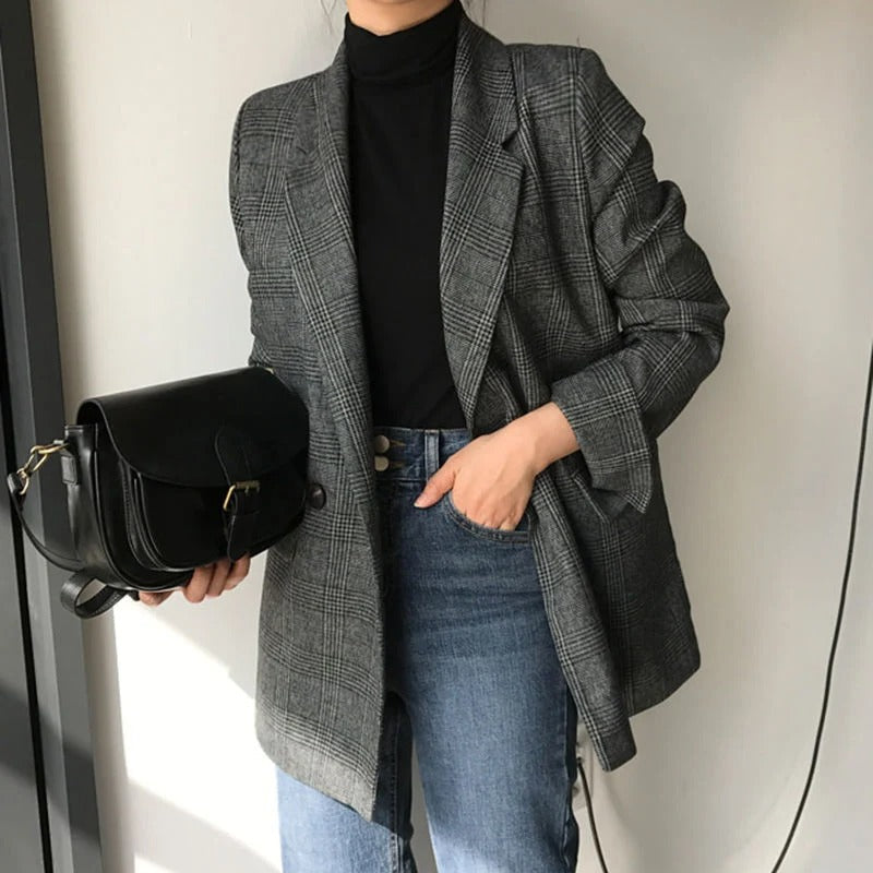 Damenmode: Eleganter grauer Karoblazer kombiniert mit schwarzem Rollkragenpullover und blauer Jeans. Perfekt für stilvolle Herbst-Looks.