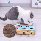 Weiße Katze spielt mit interaktivem Katzenspielzeug aus Pappe auf Holzboden.