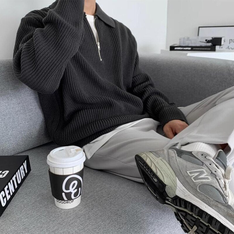 Schwarzer Strickpullover mit Reißverschluss, kombiniert mit grauer Hose und New Balance Sneakers. Perfekt für lässige Herrenmode im Herbst.