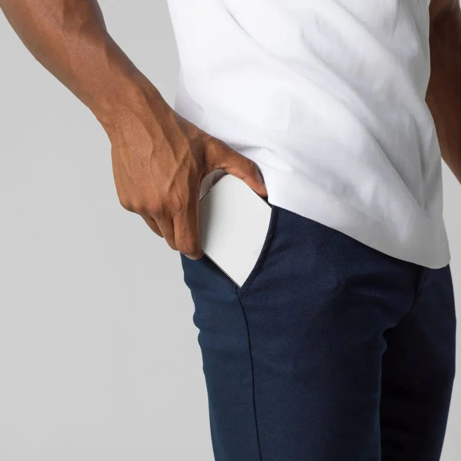 Mann in blauer Chinohose, weiße Karte in der Tasche, modische Herrenbekleidung.