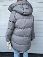 Damen Winterjacke in Hellgrau, gesteppte Daunenoptik, mit Kapuze. Modische, warme Oberbekleidung für kalte Tage. Ideal für Herbst und Winter.
