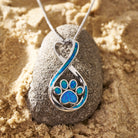 Opal-Infinity-Liebe-Pfoten-Halskette auf Sandstein, silbernes Design, ideal für Tierliebhaber, modisches Schmuckstück, Geschenkidee.