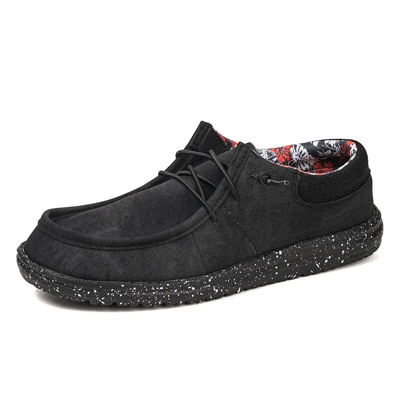 Schwarzer Herren-Slip-On-Schuh aus Canvas, leicht und bequem. Modischer Loafer mit gepunkteter Sohle, ideal für lässige Anlässe.