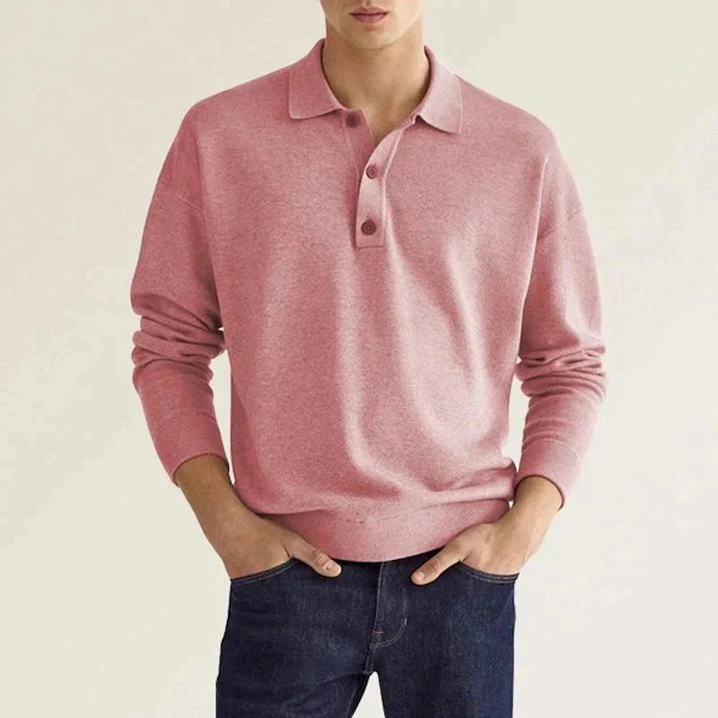 Rosa Poloshirt für Herren aus Baumwolle, langärmelig, klassischer Kragen, ideal für Freizeit und Büro, kombiniert mit dunkelblauer Jeans.