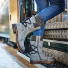 Damenstiefel aus grauem Leder mit Schnürung und Reißverschluss, kombiniert mit blauen Jeans. Perfekt für Herbstmode und Outdoor-Aktivitäten.