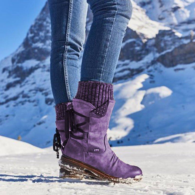 Lila Winterstiefel für Damen im Schnee, modisch und warm, ideal für Outdoor-Aktivitäten. Perfekt für kalte Wintertage in den Bergen.