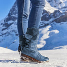 Blaue Winterstiefel für Damen im Schnee, warm gefüttert, rutschfeste Sohle, ideal für Outdoor-Aktivitäten in kalten Bergregionen.