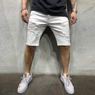 Mann trägt weiße zerrissene Jeansshorts, schwarze T-Shirt, weiße Sneakers, modischer Streetwear-Look.