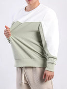 Mann trägt zweifarbiges Sweatshirt, weiß und grün, aus Baumwolle, lässiger Stil.