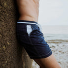 Marineblaue Herren-Badeshorts aus recyceltem Polyester mit weißen Nähten, ideal für nachhaltige Mode und umweltfreundlichen Strandstil.