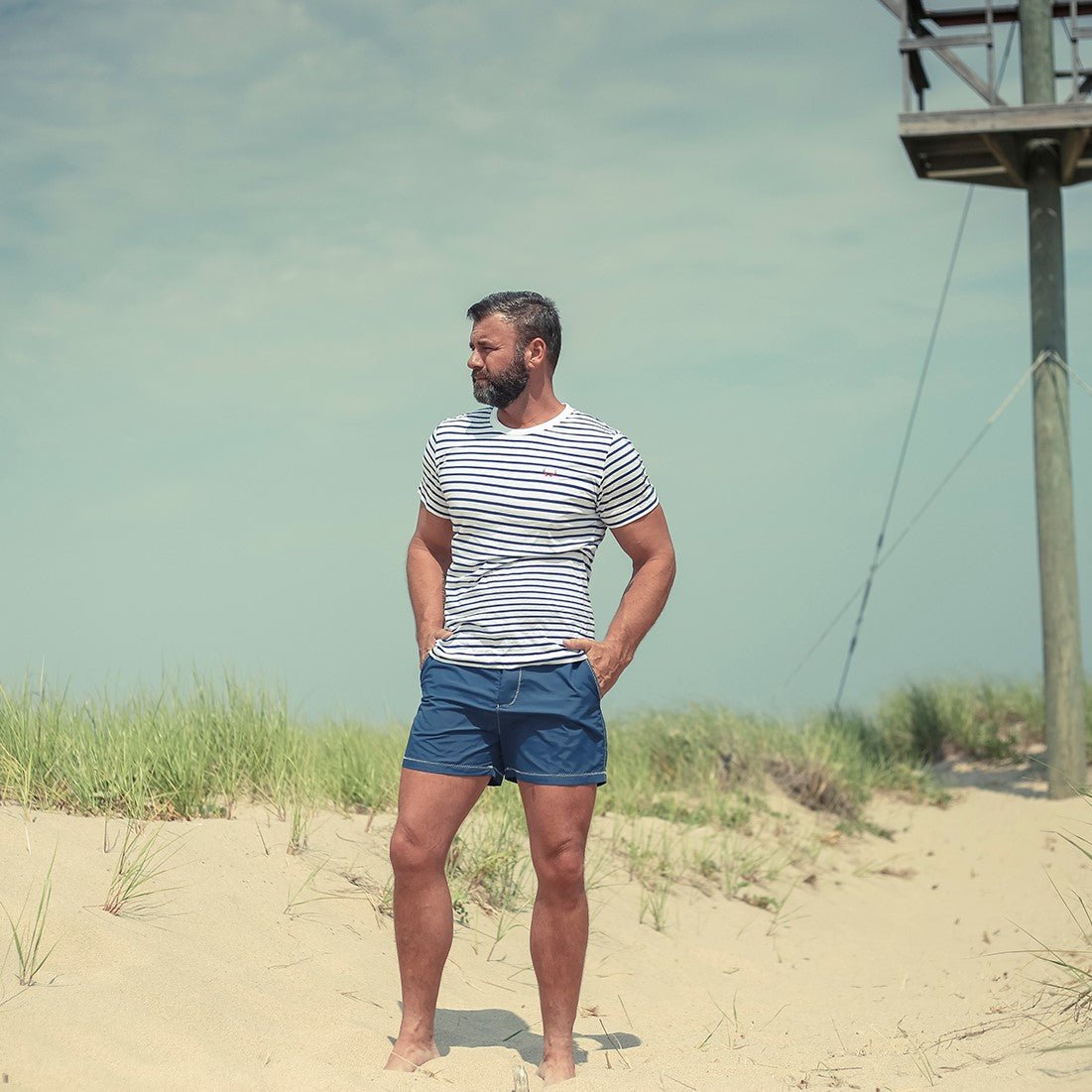 Marineblauer Herren-Badeshort aus recyceltem Polyester mit roten Details, ideal für umweltbewusste Strandmode. Nachhaltige Bademode.