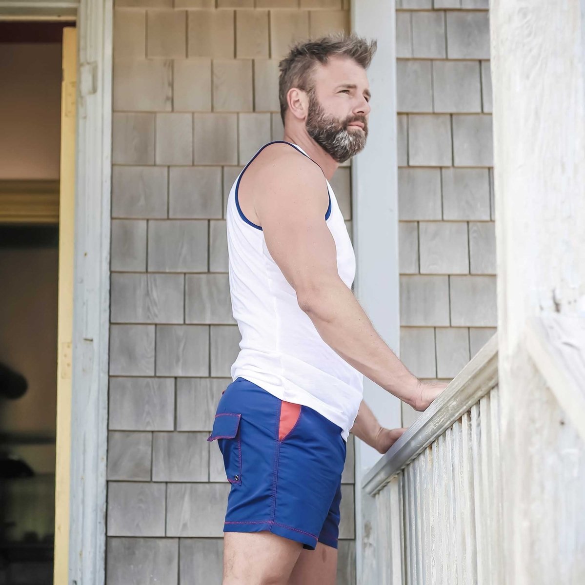 Marineblaue Herren-Badeshorts aus recyceltem Polyester mit roten Details, ideal für nachhaltige Mode und umweltbewusste Strandbekleidung.