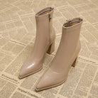 Beige Stiefeletten mit spitzem Absatz, Reißverschluss und Blockabsatz auf Vintage-Zeitungshintergrund. Modische Damenstiefel für Herbst/Winter.