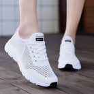 Weiße Sneaker mit atmungsaktivem Mesh-Design, ideal für Damen. Bequeme Sportschuhe, perfekt für Freizeit und Fitness. Trendige Mode 2023.