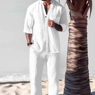 Eleganter weißer Leinenanzug für Herren am Strand, ideal für Sommermode. Perfekt für lässige Anlässe und Urlaubsoutfits.