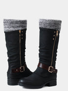 Schwarze Damenstiefel mit Strickbündchen, seitlichem Reißverschluss und Schnallen. Modische Winterstiefel, ideal für kalte Tage.